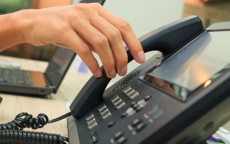 An employee answering up their VoIP phone.