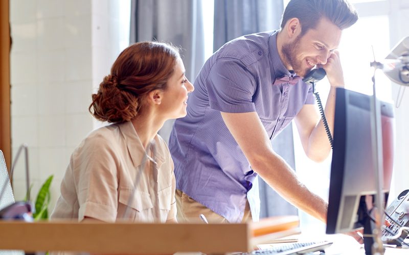 A creative duo working together while one is on a call.